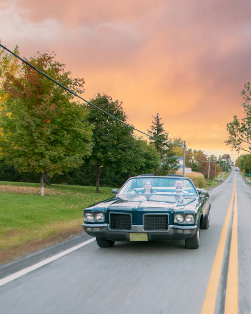 Old blue 1971 convertible car taking a ride at sunset