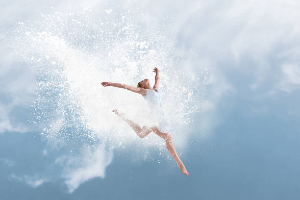 Beautiful ballet dancer jumping inside cloud of powder stock photo