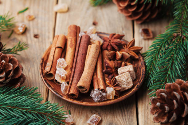 istock Christmas spices in plate on wooden rustic table. Anise star, cinnamon sticks and brown sugar. 877650430