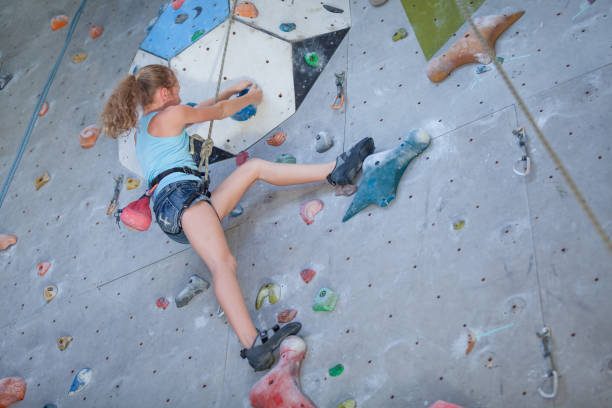 istock teenager climbing a rock wall 877665358