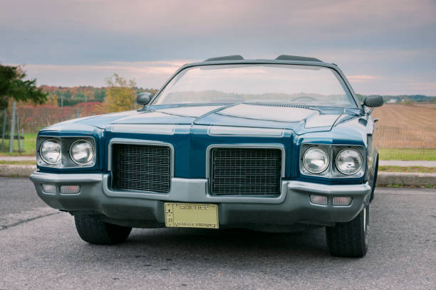 Old blue 1971 convertible car parked at sunset