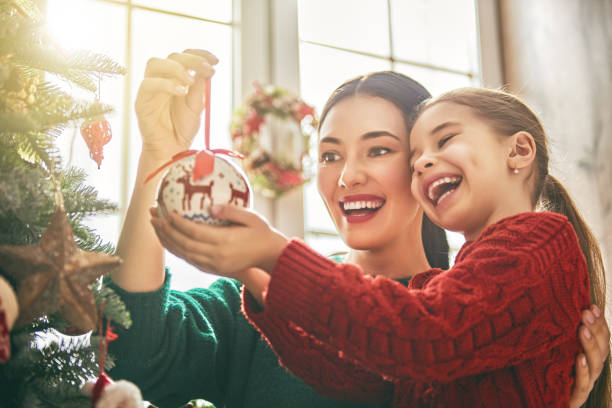 istock Mom and daughter decorate Christmas tree 877695240