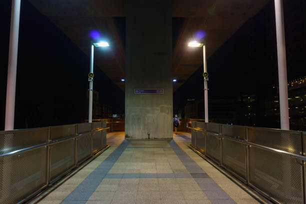 istock empty pathway on the overpass bridge under the skytrain railway track at night. 877695534