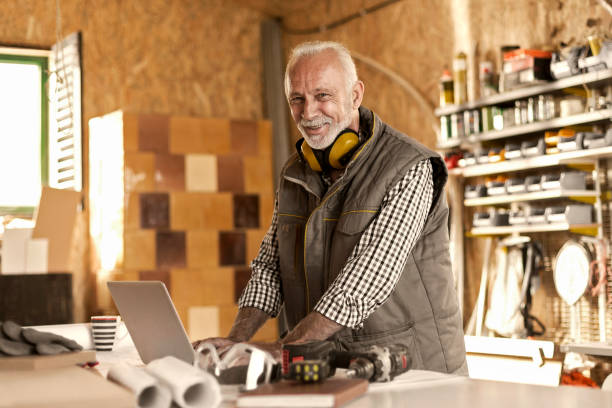 istock Mature designer in his workshop on laptop posing 877698520