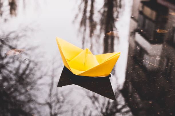 istock Imagination and inspiration. Yellow Paper Boat 877698926