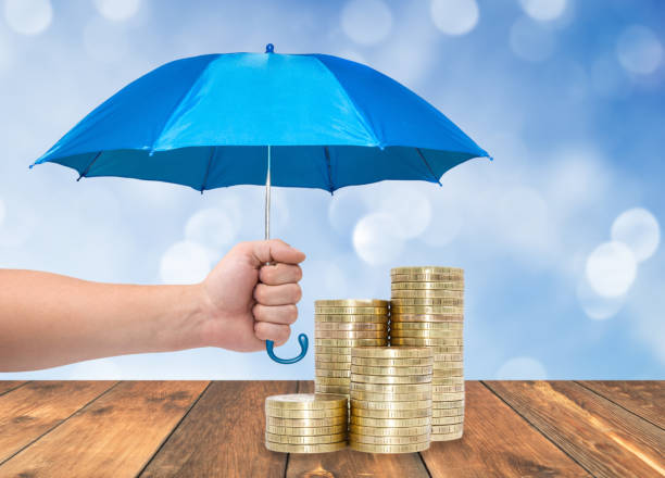 istock Coins under a blue umbrella protection money concept 877699730