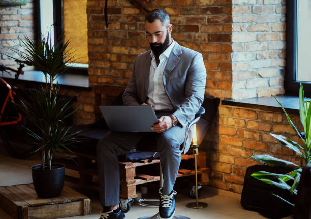 istock Stylish bearded male works with a laptop. 877709776