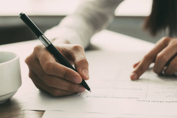 istock Closeup of Woman Completing Application Form 877714750