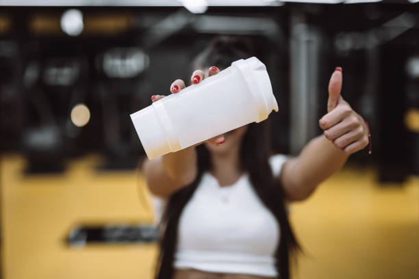 istock Young woman drinking from water bottle 877717762