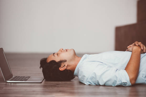 istock Asian man lying on floor at his laptop 877717876