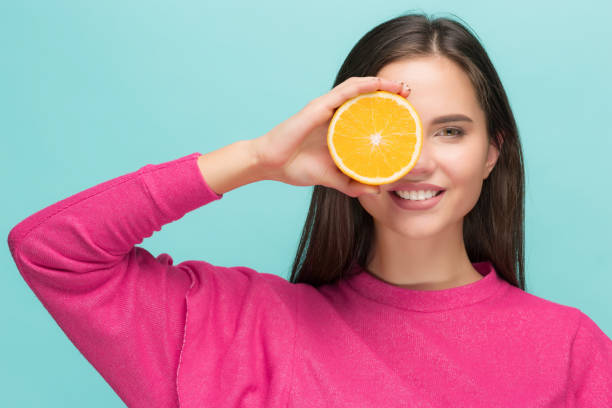 istock Beautiful woman's face with juicy orange 877718466