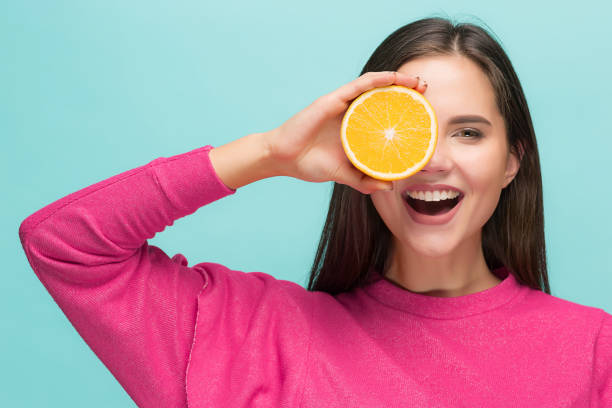 istock Beautiful woman's face with juicy orange 877718722