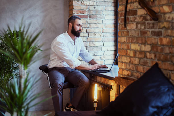 istock Stylish bearded male works with a laptop. 877719206