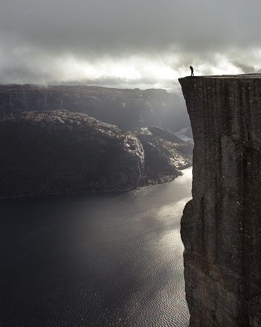 A man on the edge of a high cliff in Norway