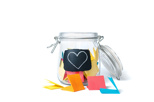 Open Bank with colorful stickers on a white background with white chalk-drawn heart