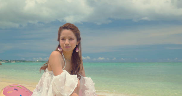 istock Japanese female sitting on the beach. 877760546
