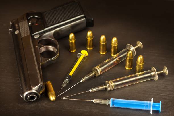 sales of narcotics. weapon and drugs on the table. handgun and ammunition. - addiction ammunition weapon army imagens e fotografias de stock