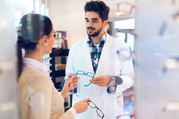 istock Young woman selecting eyeglasses in optical shop 877764212