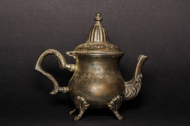 istock Silver antique teapot on a black background. 877767318