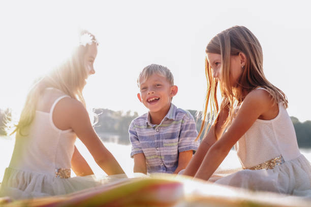 Three cute kids laughing together in nature