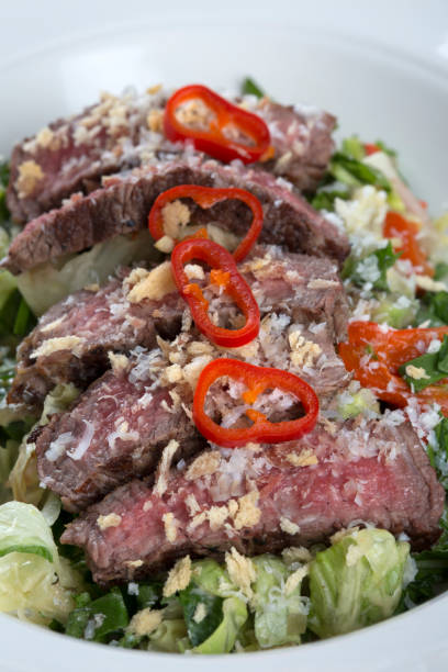 istock green leaf salad with sliced meat on it 877778396