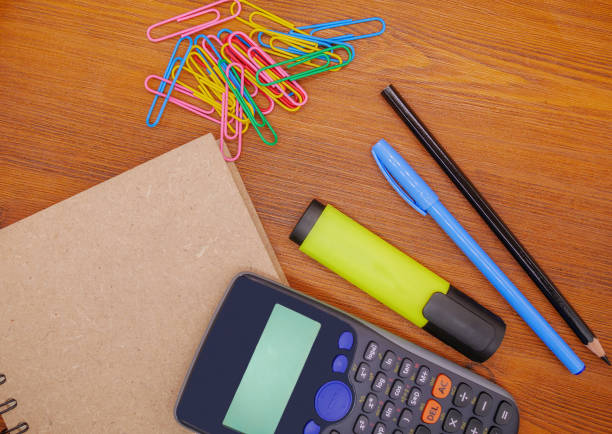 istock Top view notebook,calculator and stationery on brown wooden table 877781156