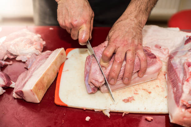 istock Man slicing pork meat on a table, conceptual idea 877791120