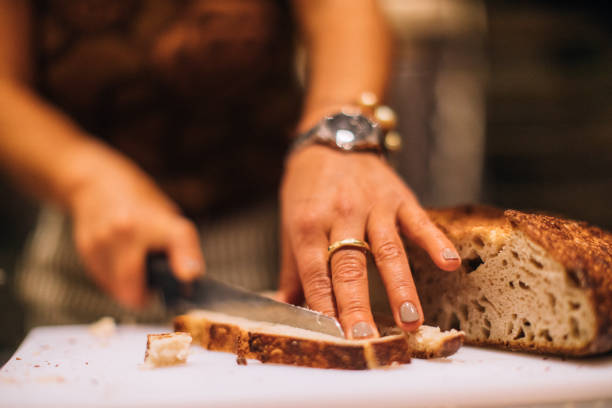 istock Woman cutting a slice of bread 877793890