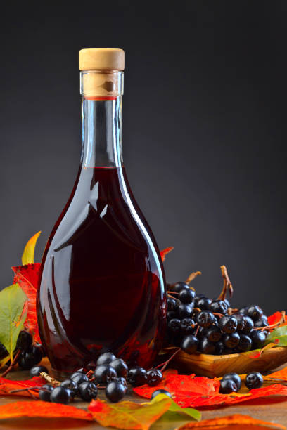 istock Black chokeberry and bottle with juice . 877794488