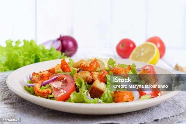Light Tasty Salad With Meat Of A Cancer Shrimps Lettuce Garlic Croutons Tomatoes Red Onions On A White Background Stock Photo - Download Image Now