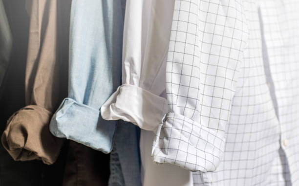 Closet wardrobe interior, showing men's dress shirts with folded and cuffed cuffs, white, blue, brown and black shirts, with light tones and soft focus Mens clothing and fashion mens fashion stock pictures, royalty-free photos & images