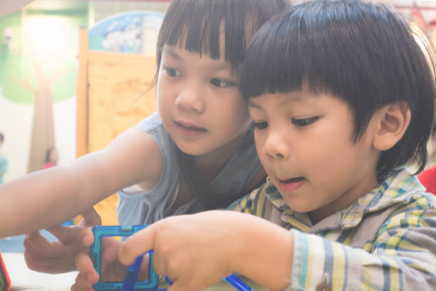 istock Two small kids are playing with educational toy in classroom 877811472