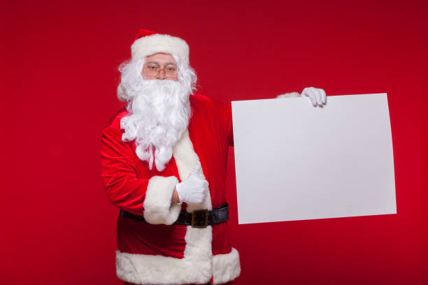 istock Santa Claus pointing in blank advertisement banner isolated on red background with copy space 877829954