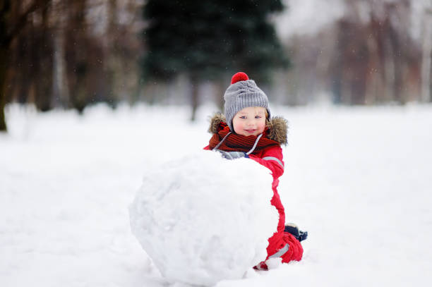 少年は雪だるまを楽しんで赤冬服 - 5597 ストックフォトと画像