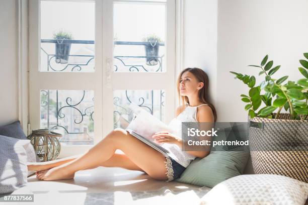 Junge Hübsche Mädchen Lesen Fashionmagazin In Der Nähe Von Fenster Stockfoto und mehr Bilder von Lesen