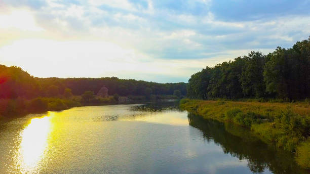 istock Aerial Drone Flight Footage: Back Flight above calm Water and forest in sunset soft light. Magestic landscape 877842378