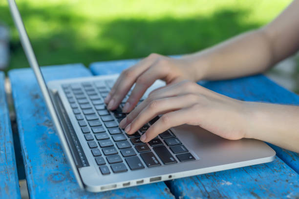 istock Woman hands working on laptop outdoors 877850196