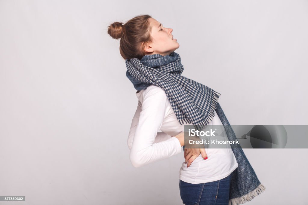 Profile view sick woman which hurts the back or kidneys Profile view sick woman which hurts the back or kidneys. Indoor shot Adult Stock Photo