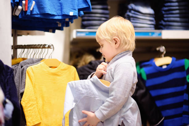 istock Cute little boy trying new clothes during shopping 877853840