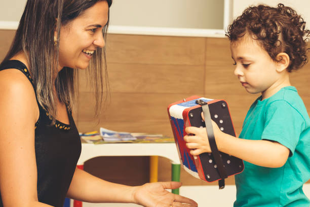 istock Mother teaching accordion to her son. 877861044