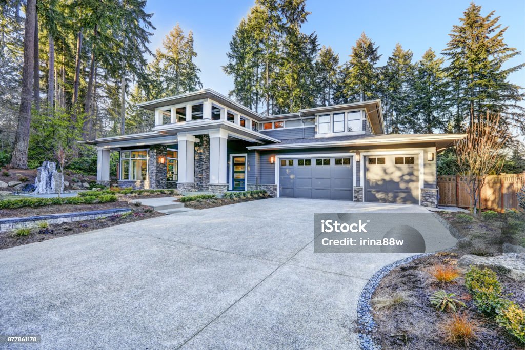 Luxurious new construction home exterior Luxurious new construction home exterior with two garage spaces and wide driveway at sunrise. Northwest, USA Driveway Stock Photo