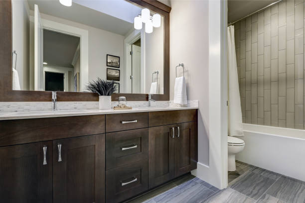 White and brown bathroom boasts a nook filled with double vanity