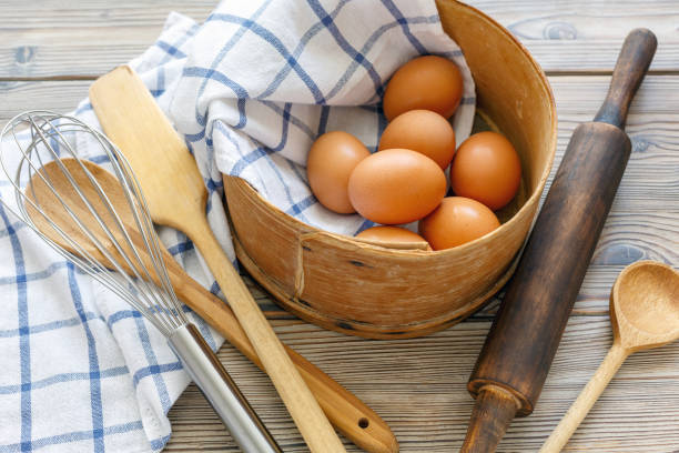 istock Kitchen utensils and brown eggs in an old sieve. 877862600