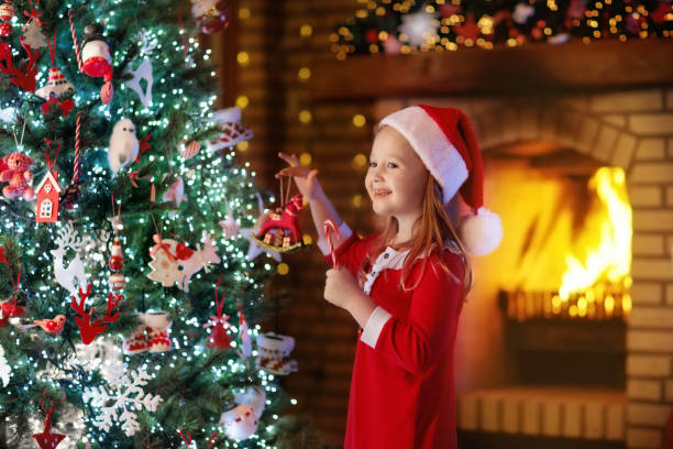 istock Child at Christmas tree and fireplace on Xmas eve 877873606