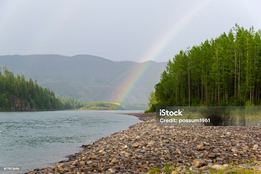 Rainbow over the river. Rainbow over the river. Oka Sayanskaya river at the end of the gorge Orkho-Bom, Eastern Sayan, Siberia, Russia. The beginning of August. Canyon Stock Photo