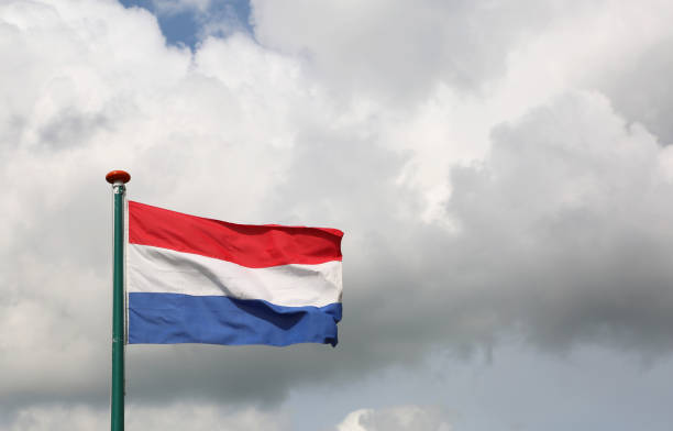 istock Dutch flag waving with cloudy sky background 877876290