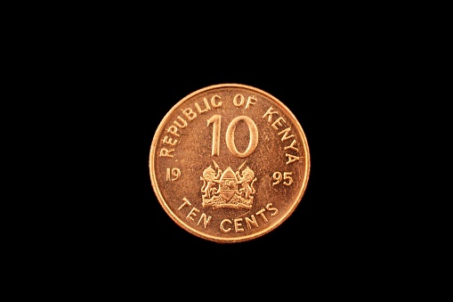 A super macro image of a Kenyan ten cent coin isolated on a black background