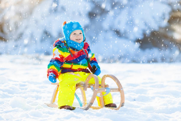 istock Boy on sleigh ride. Child sledding. Kid with sledge 877878012