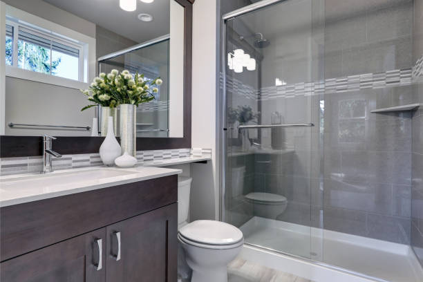 istock Bright new bathroom interior with glass walk in shower 877880394