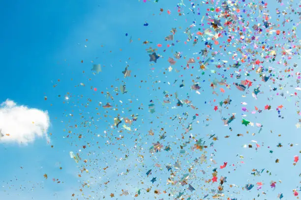 Photo of Colorful paper confetti blue sky background